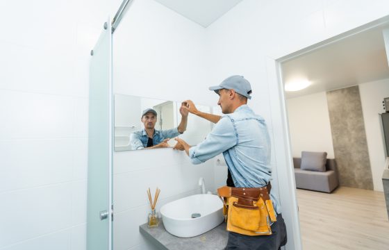 Handyman,Installing,Mirror,In,Bathroom.