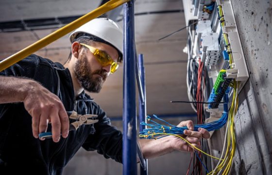 A male electrician works in a switchboard with an electrical connecting cable, connects the equipment with tools. SSUCv3H4sIAAAAAAAACpyRwW7DIAyG75P2DhHnRkqa0CZ7lWoHB0iCSqEC0mmq+u4zECrOu+HP9m//5vn5UVVkAicZ+aqeIcJYKrU5b8FLoxE3h51bobmwJXnY7tSUQHDpjZWgSjiBZ6uGm0CoN6UCfsUkcR785oQL03fEwIsFNRJ8S6QVLymuciImsQNThBwK5rYpsoyS+L860+M7u4FFaPYbFy6MWKEEJCOXVEquP17YW2kNNi5N4ephGKhQ0BVKdyuZ1EvRZvwaz57bmNm0t2GF9+ZEGXOHSYUTz6gpMl/BOSznmReDGH6yuRVztPHRwK5KOP5ECNvueB57Oo6UNmc6DAPdC9LvrRJ14jpZCGN2lby0LsMGZGxPYmymY81nzuq+b+d6EJTVtOuGeWwaOvMeD//6AwAA//8DACSFlgGYAgAA